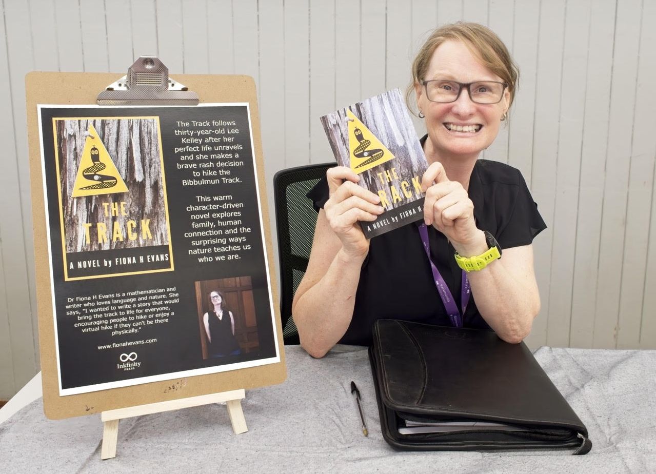 Author Fiona H Evans holding a copy of her book, The Track